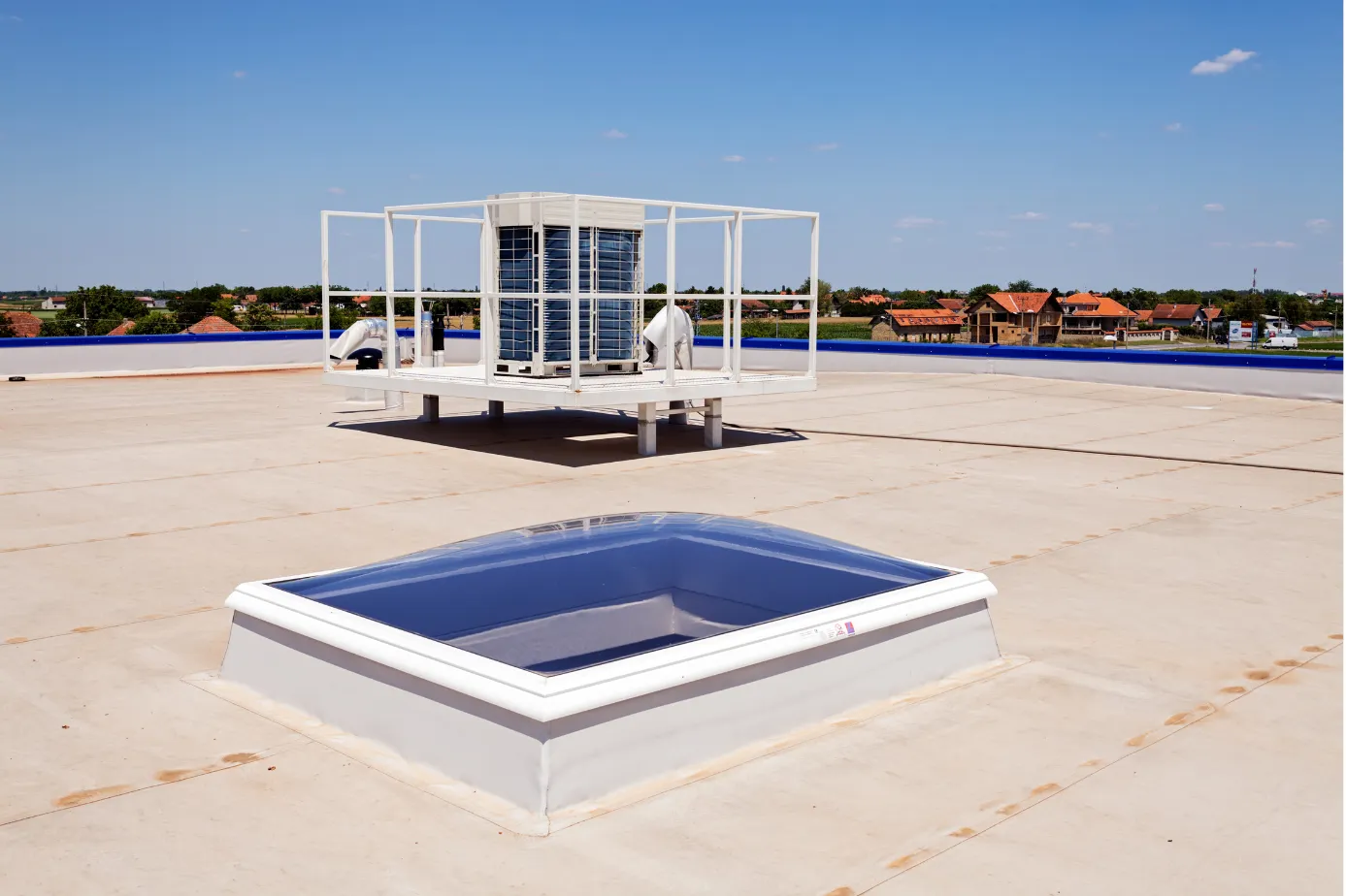 A picture of the top of a flat commercial building roof with workers on it in SLidell, LA